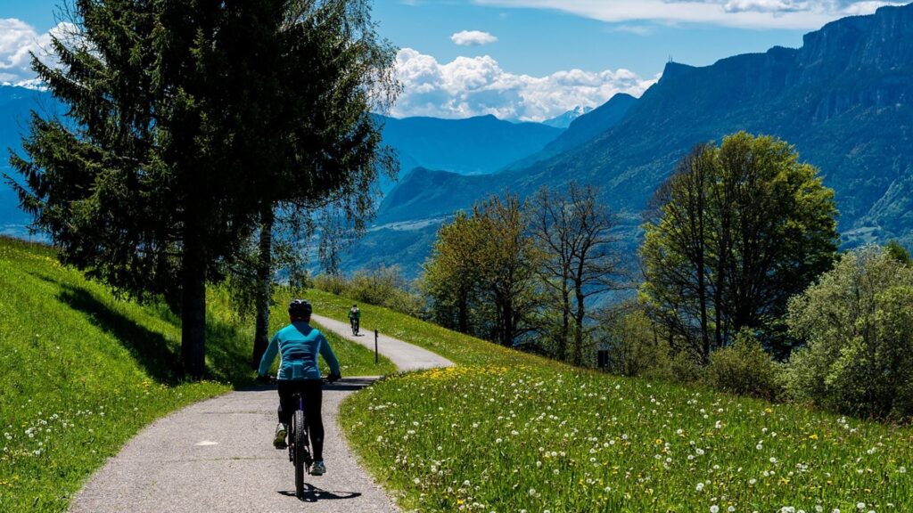 Person fährt auf einem Radweg vor Bergkulisse